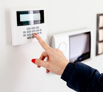 woman turning on burglar alarm